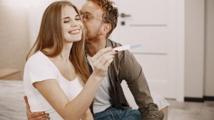 Joyful couple embracing positive pregnancy result, sharing excitement and love.